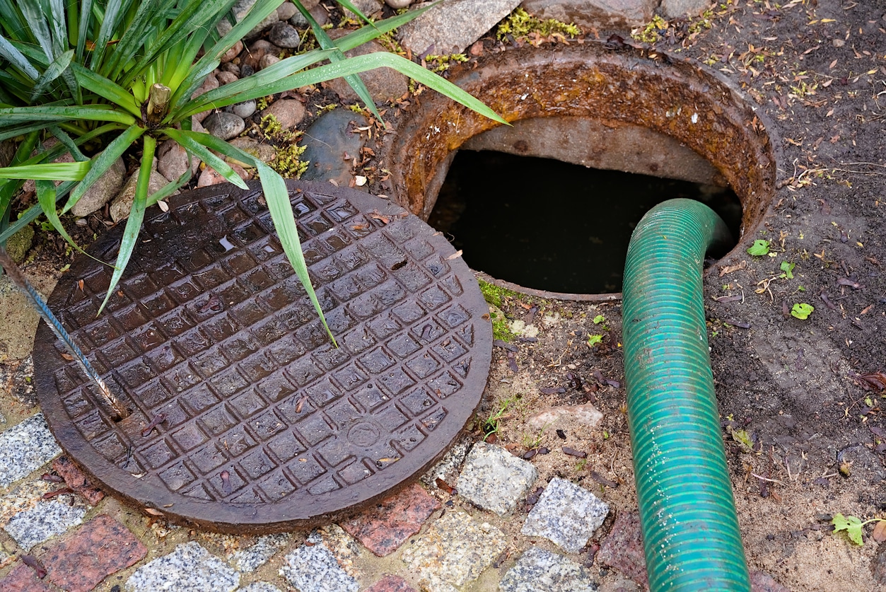 pumping septic tanks from the backyard tank in the countryside Green tube inside septic tank, demonstrating the process of expert septic pumping